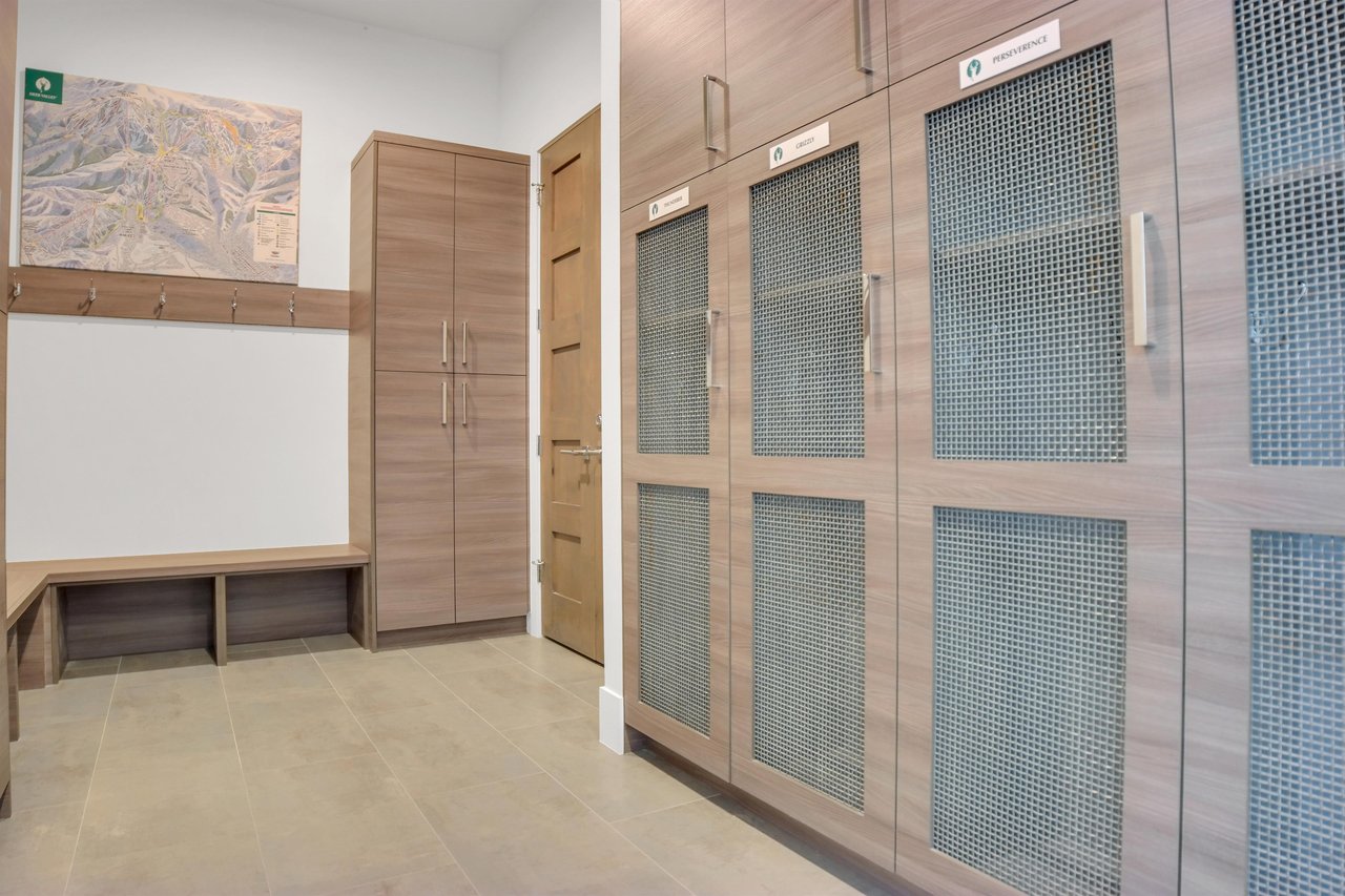 Vacation rental built in cabinets for ski storage, long bench seating and wall hangers.