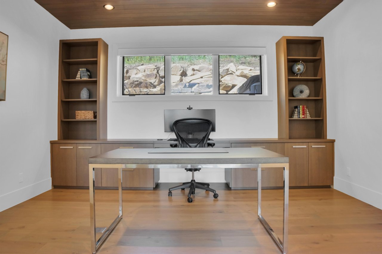 Vacation rental office with modern desk and built in wooden cabinets with built in desk.