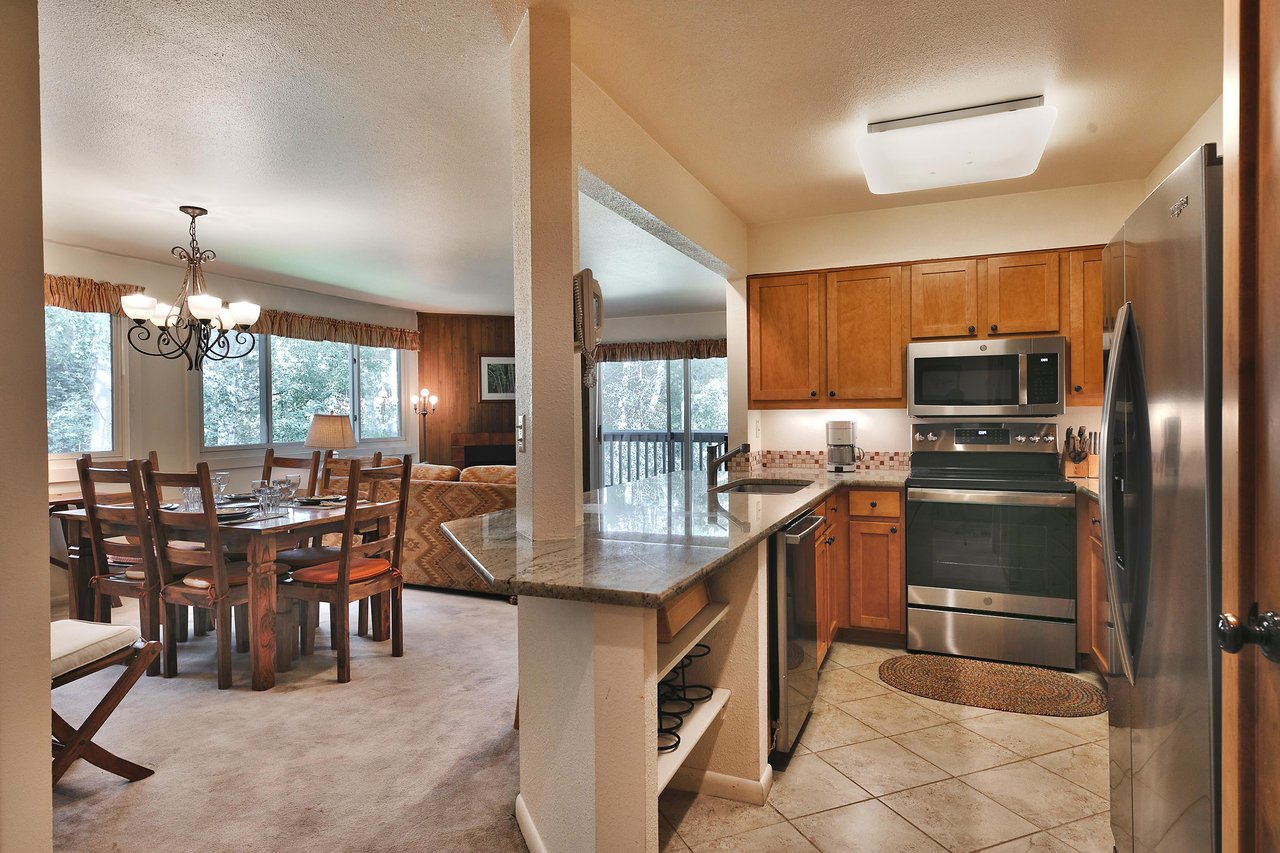 Fully equipped kitchen with granite countertops and tiled floors, wooden cabinets and stainless steel appliances