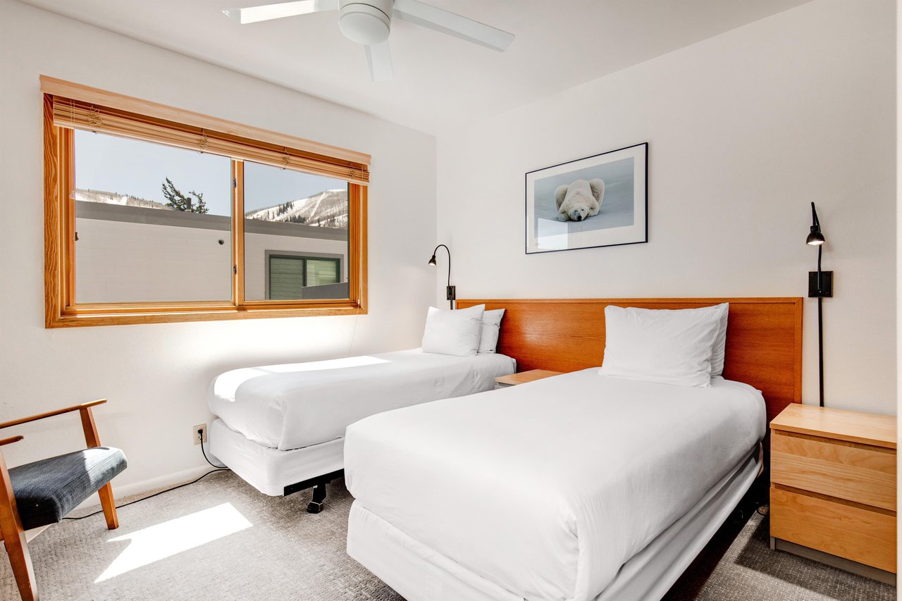 Bedroom 4 has 2 twin beds, wood headboard with 2 attached lights, shared night stand and polar bear picture.