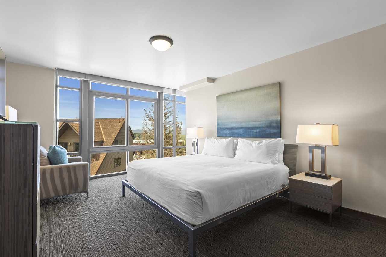 The third bedroom has a king size bed and views out of floor to ceiling windows.