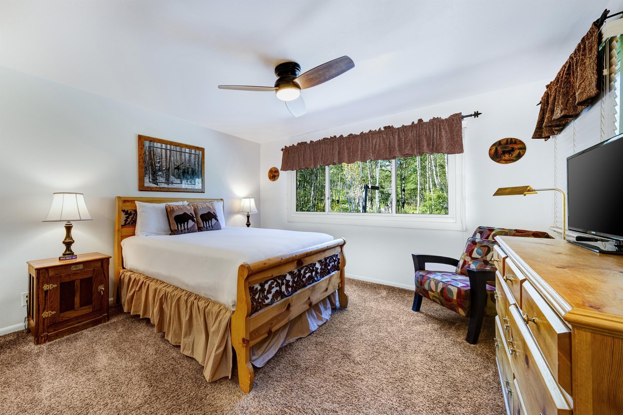 The main bedroom features a comfortable queensized bed with white linen