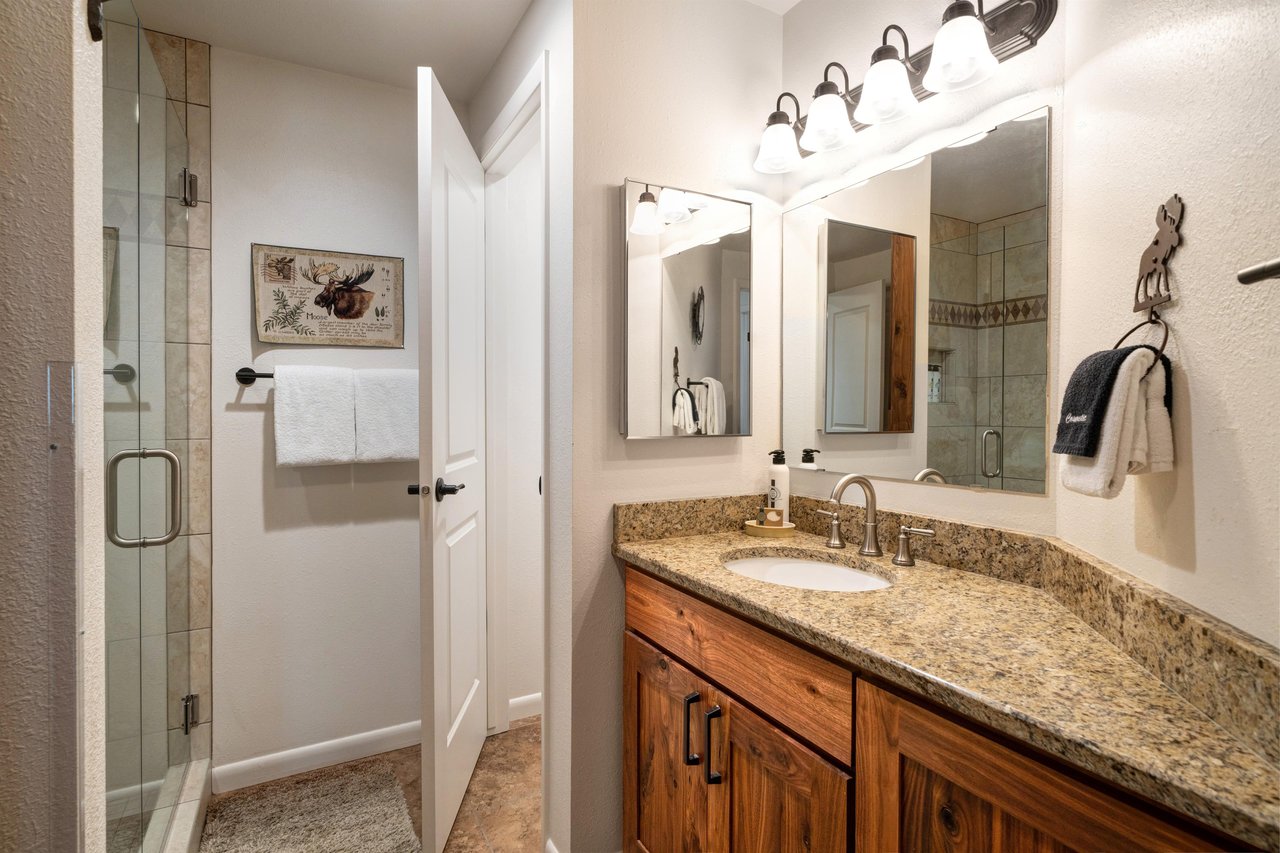 The second bedrooms shared bathroom has a  single vanity sink with granite countertop.