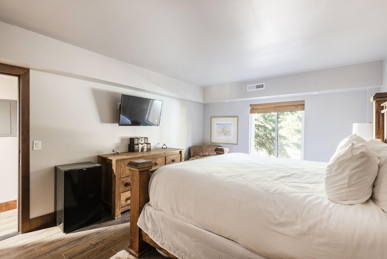 Bright natural light in the main bedroom, king bed