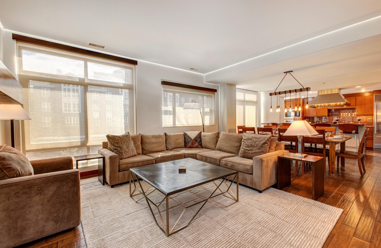 Lowell 402 living room with blinds close and large sectional sofa.