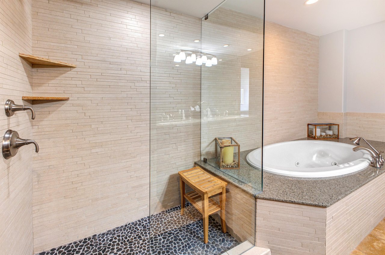 Lowell 402 main suite bathroom with double sink vanity, walk in shower and bathtub.