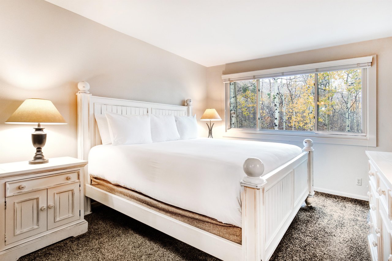 The main suite offers a king size bed and large window with forest views.