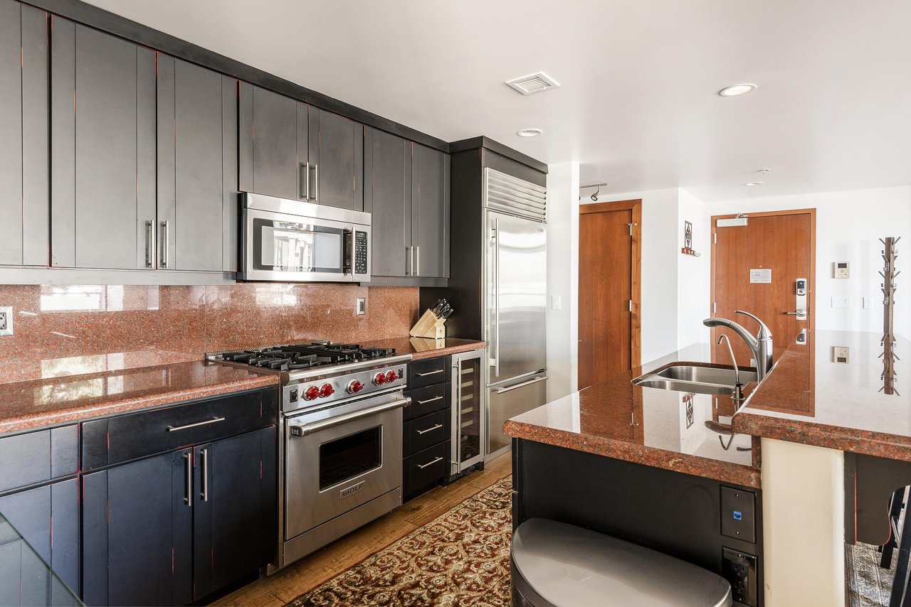 Fully equipped kitchen featuring bottom freezer stainless steel fridge, dedicated wine fridge, wolf gas range