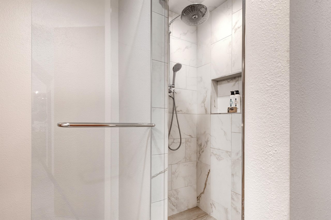 The en suite bathroom has beautiful tile work in teh shower and glass door.