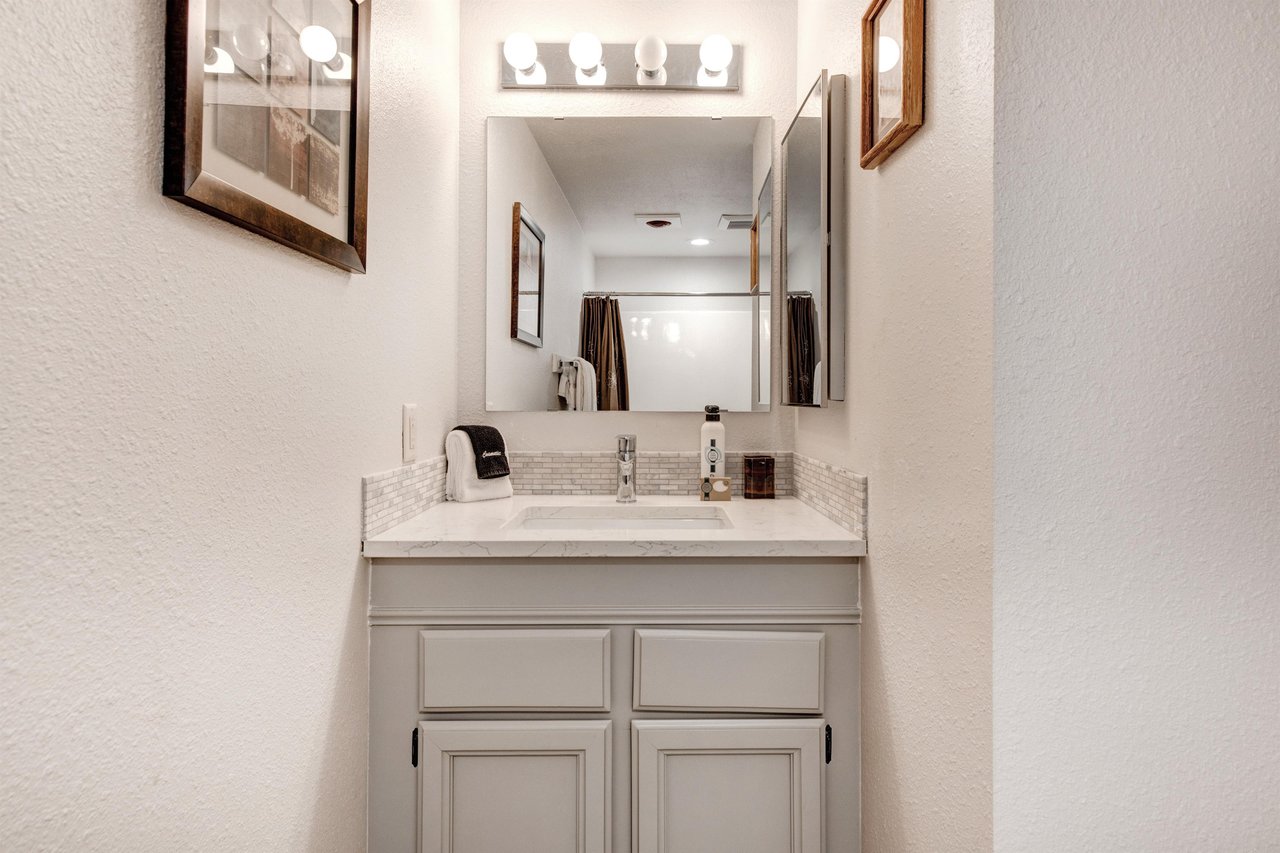 The single sink vanity with light grey cabinets.