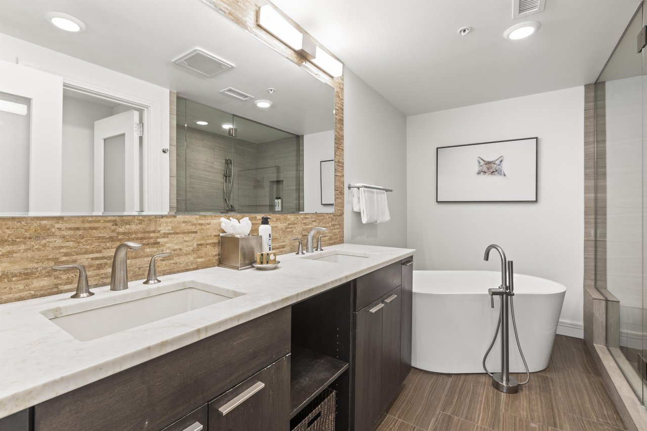 The en suite bathroom has a two sink vanity and a deep soaker tub.