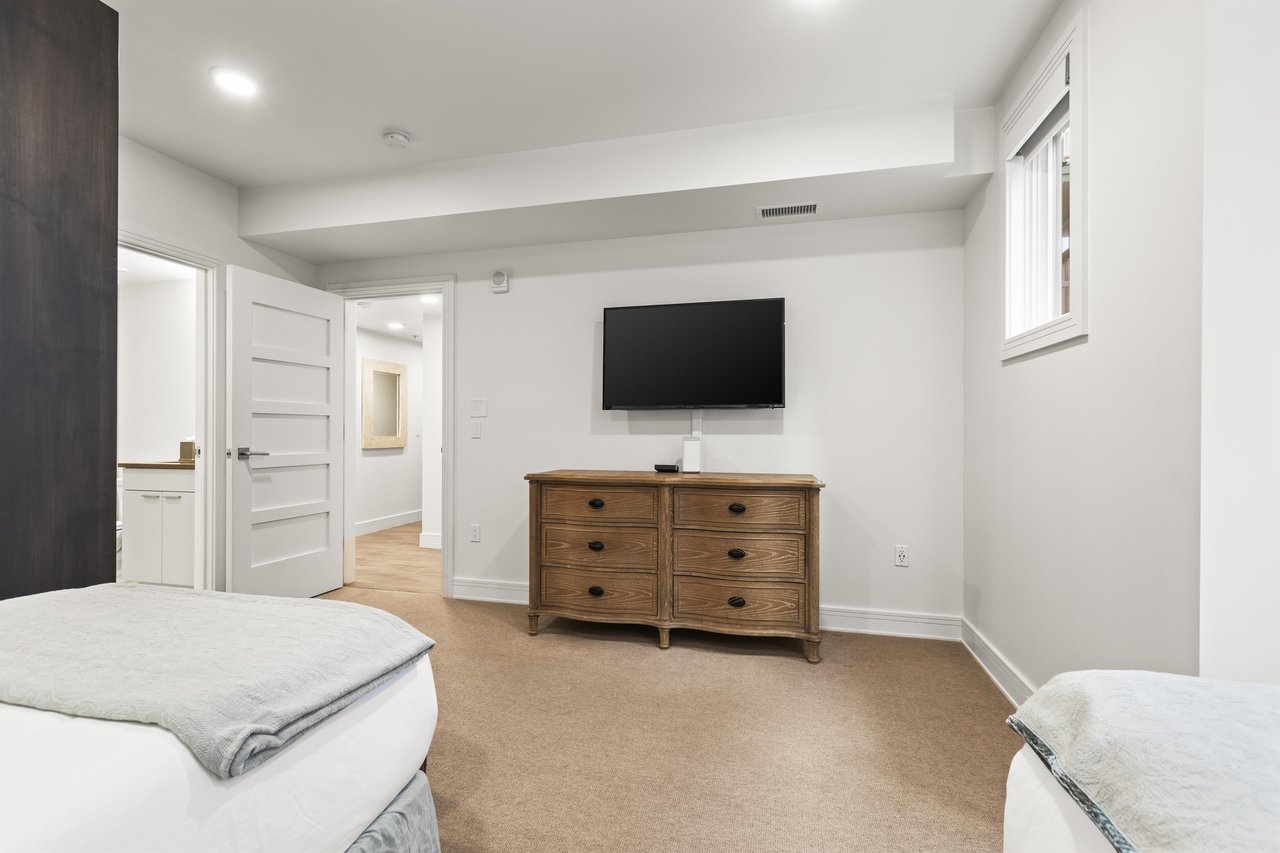 A second bedroom offers two twin beds, wooden dresser and flat screen TV.