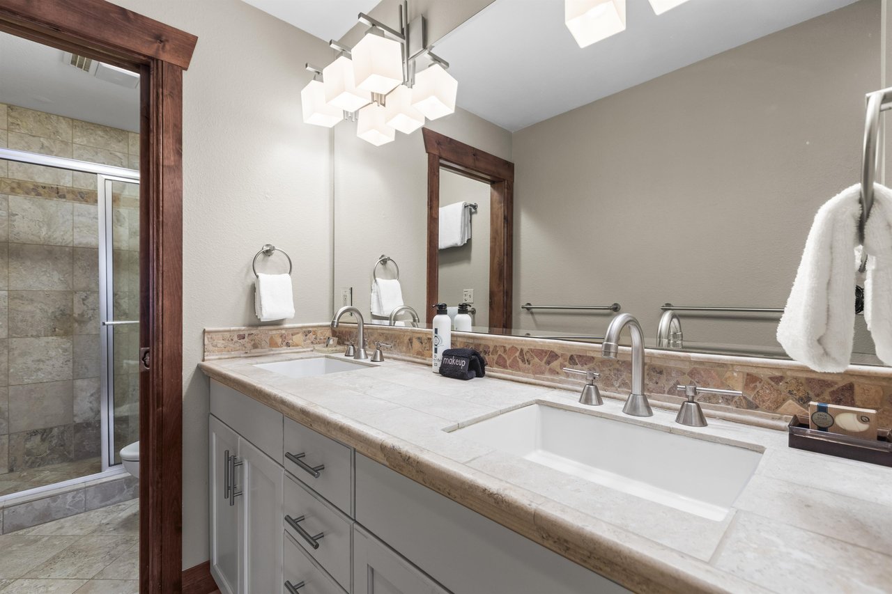 The en suite bathroom has a two sink vanity and separate water closet.