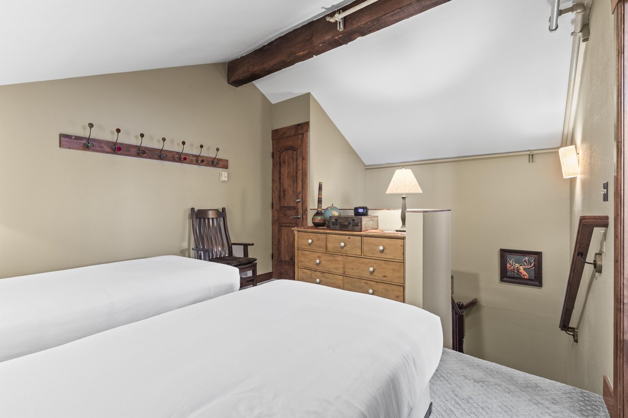 The loft offers two twin beds and wooden dresser.