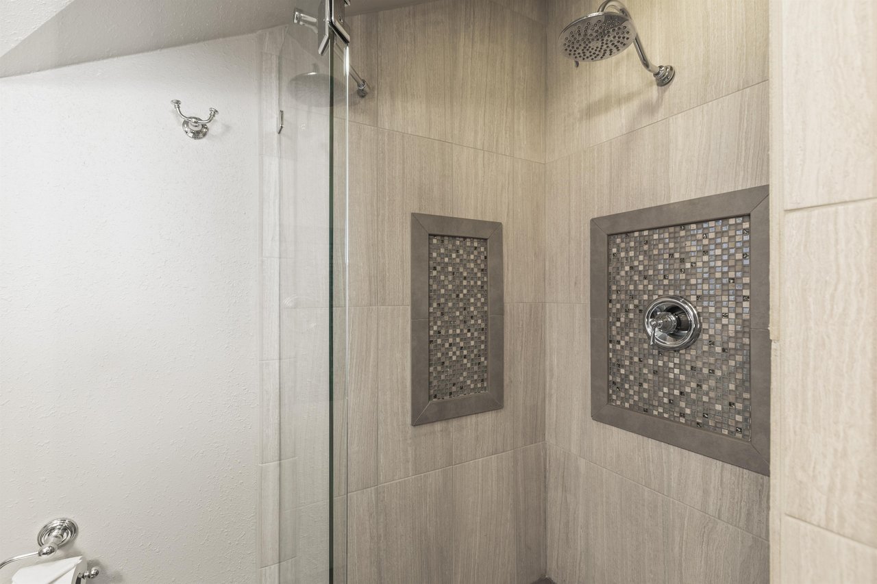 The en suite bathroom offers a walkin shower with beautiful tile.