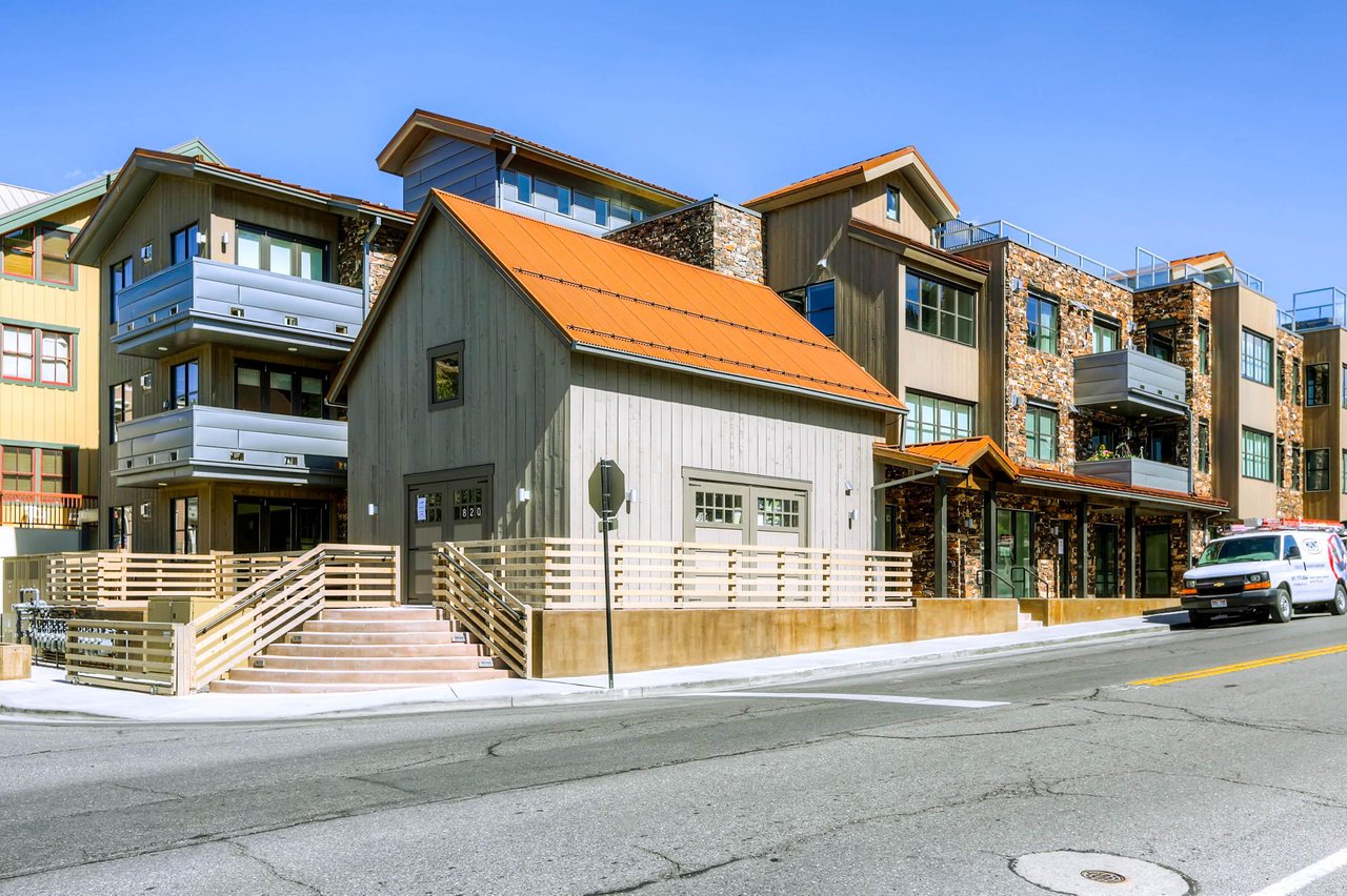 Vacation rental condo exterior with stone and metal siding and roofing.
