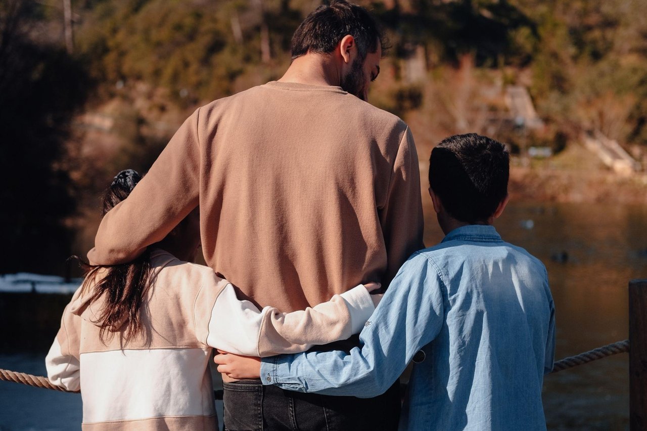 7088830 Two Young Children Hugging Dad
