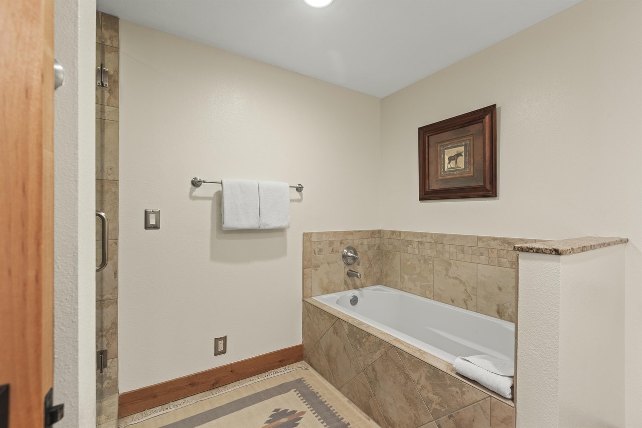 The en suite bathroom has a deep soaker bathtub.