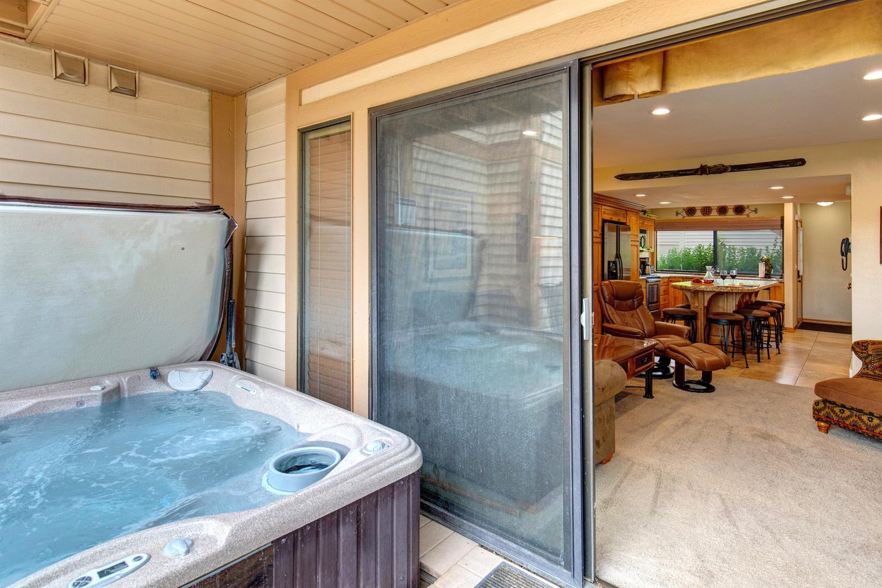 The hot tub located just outside the living room on the private patio.