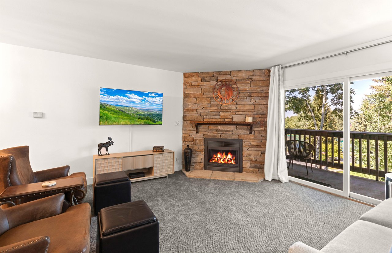 The living room has comfortable furnishings, gas burning fireplace, and flat screen TV.