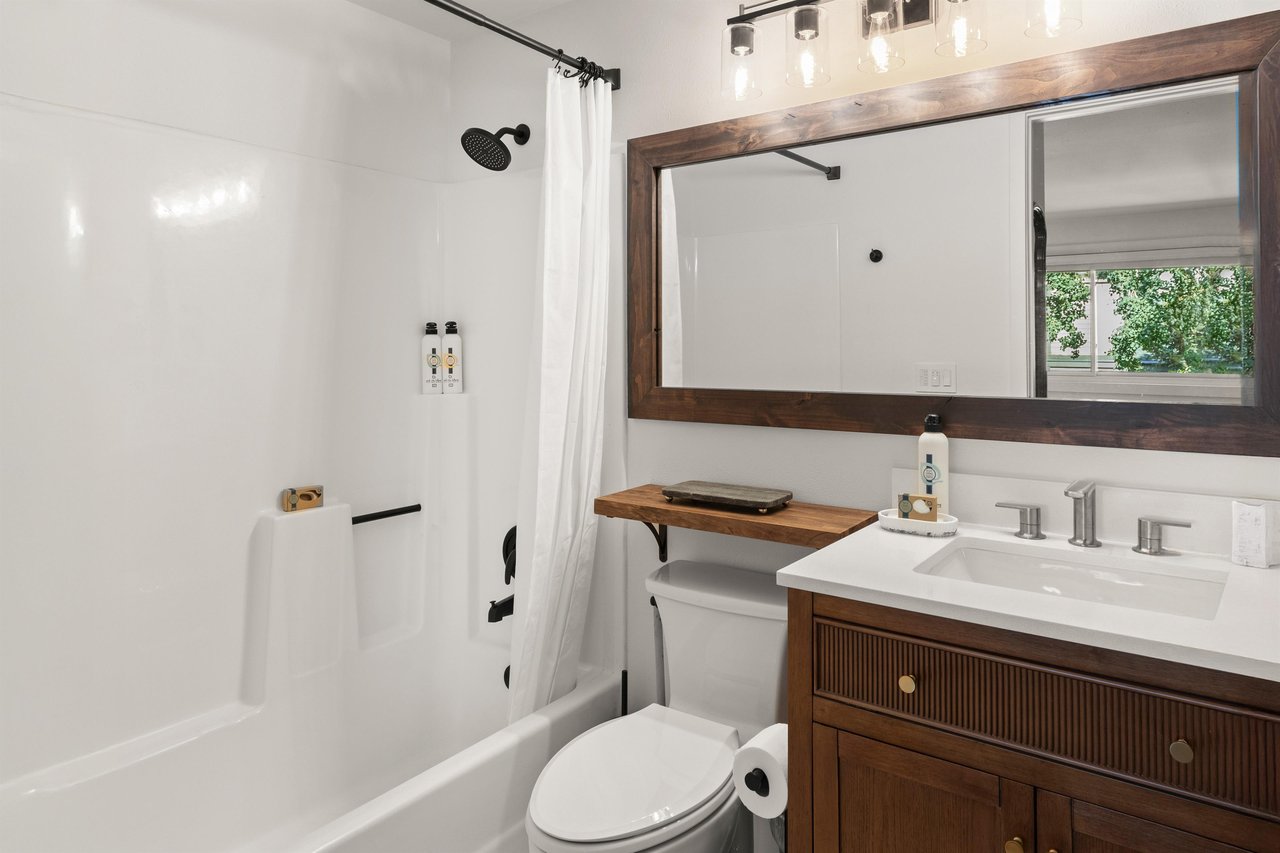 The en suite bathroom has a bathtub and shower combination and single sink vanity.