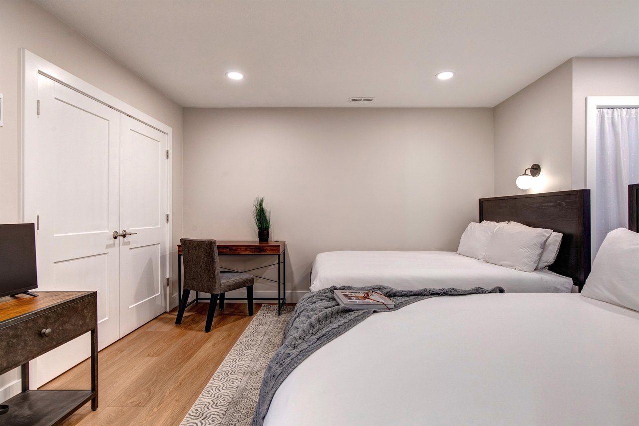 The second bedroom has two queen beds and a desk.
