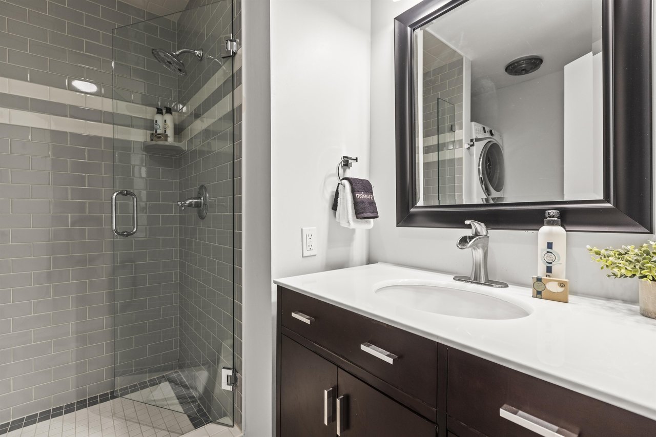 The shared bathroom with a single sink vanity and walkin shower.