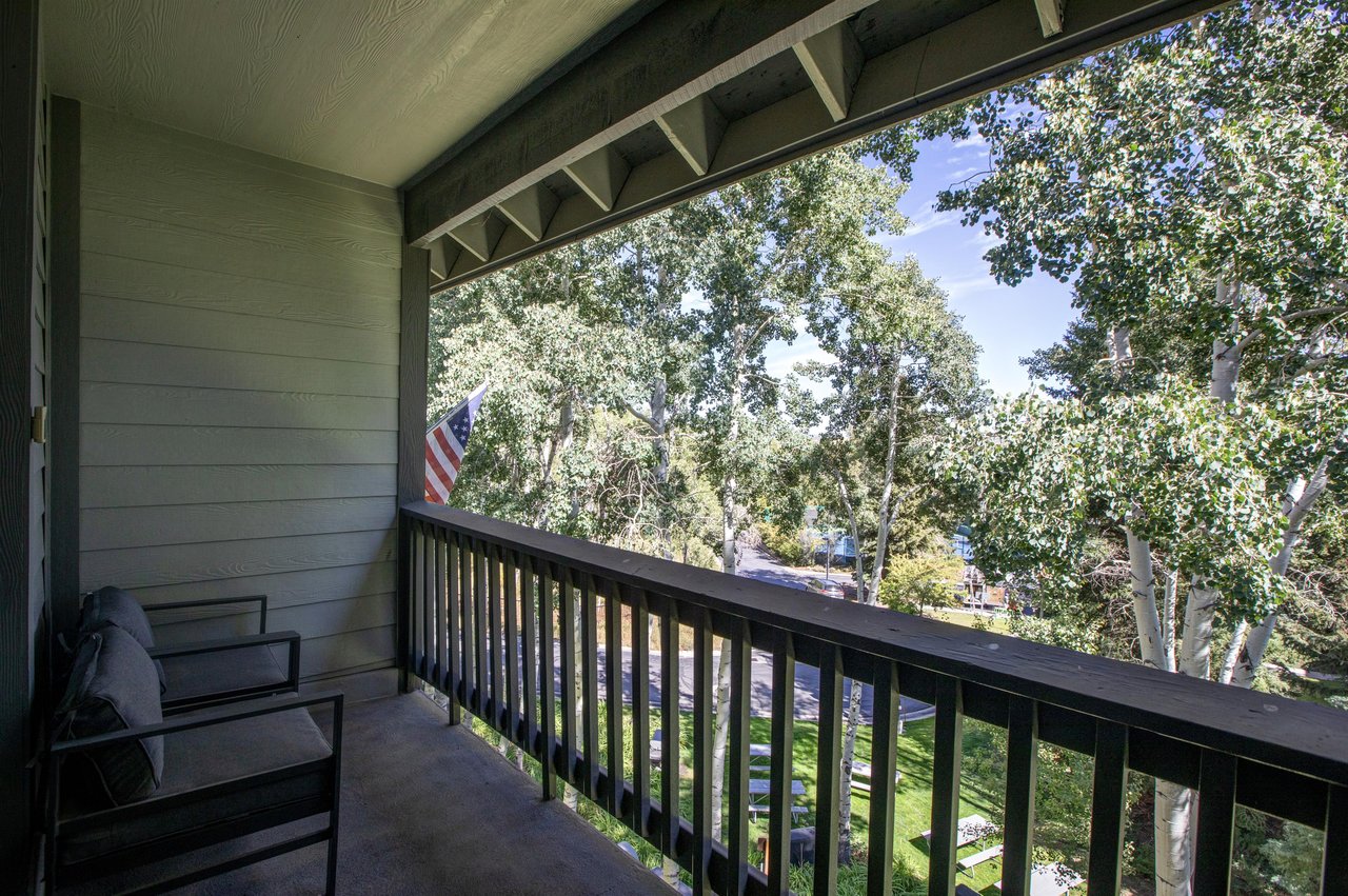 The private deck overlooks a grove of trees.