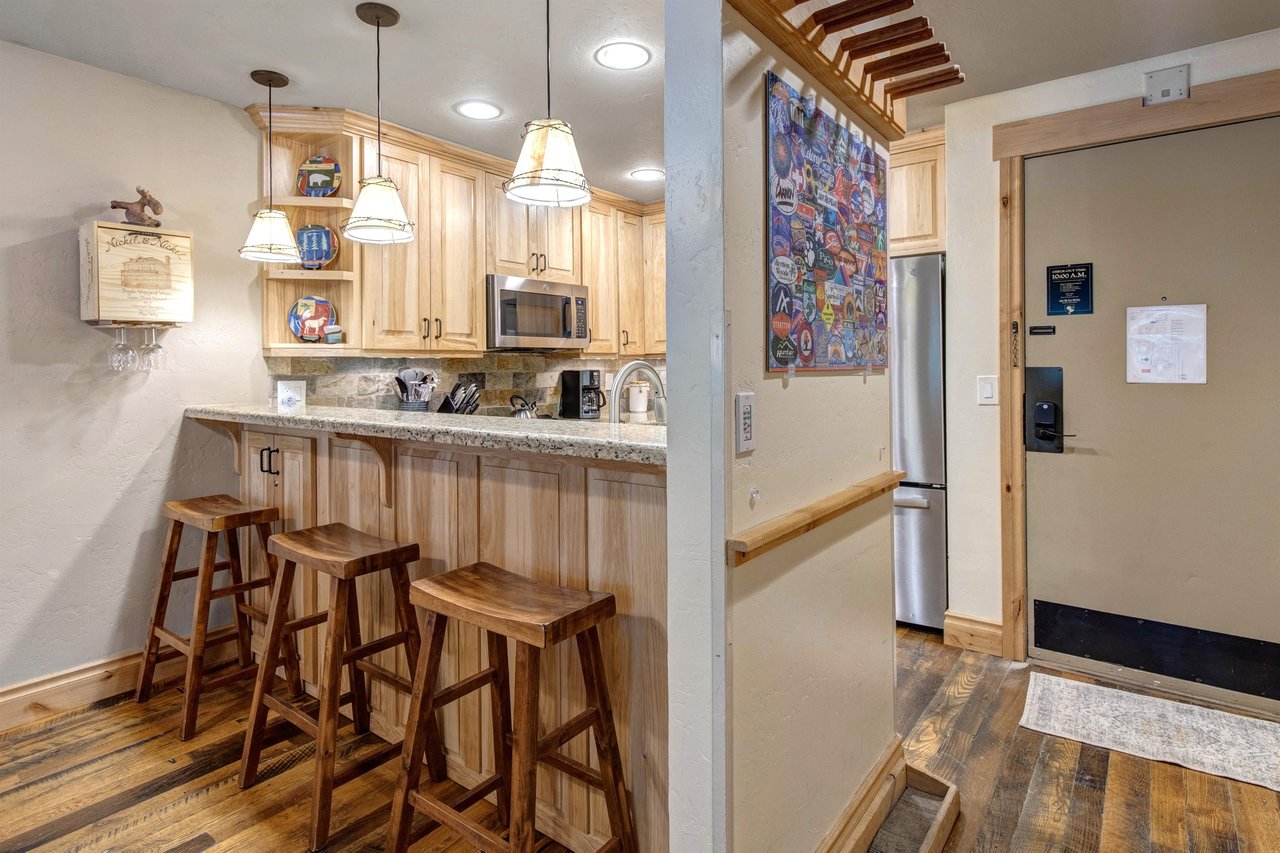The breakfast bar with seating for 3 on wooden bar stools.