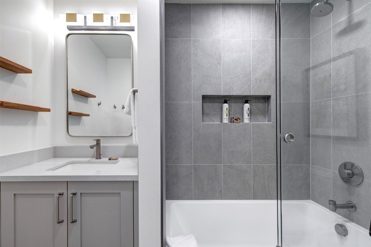 The en suite bathroom with bathtub and shower combination and one sink vanity.
