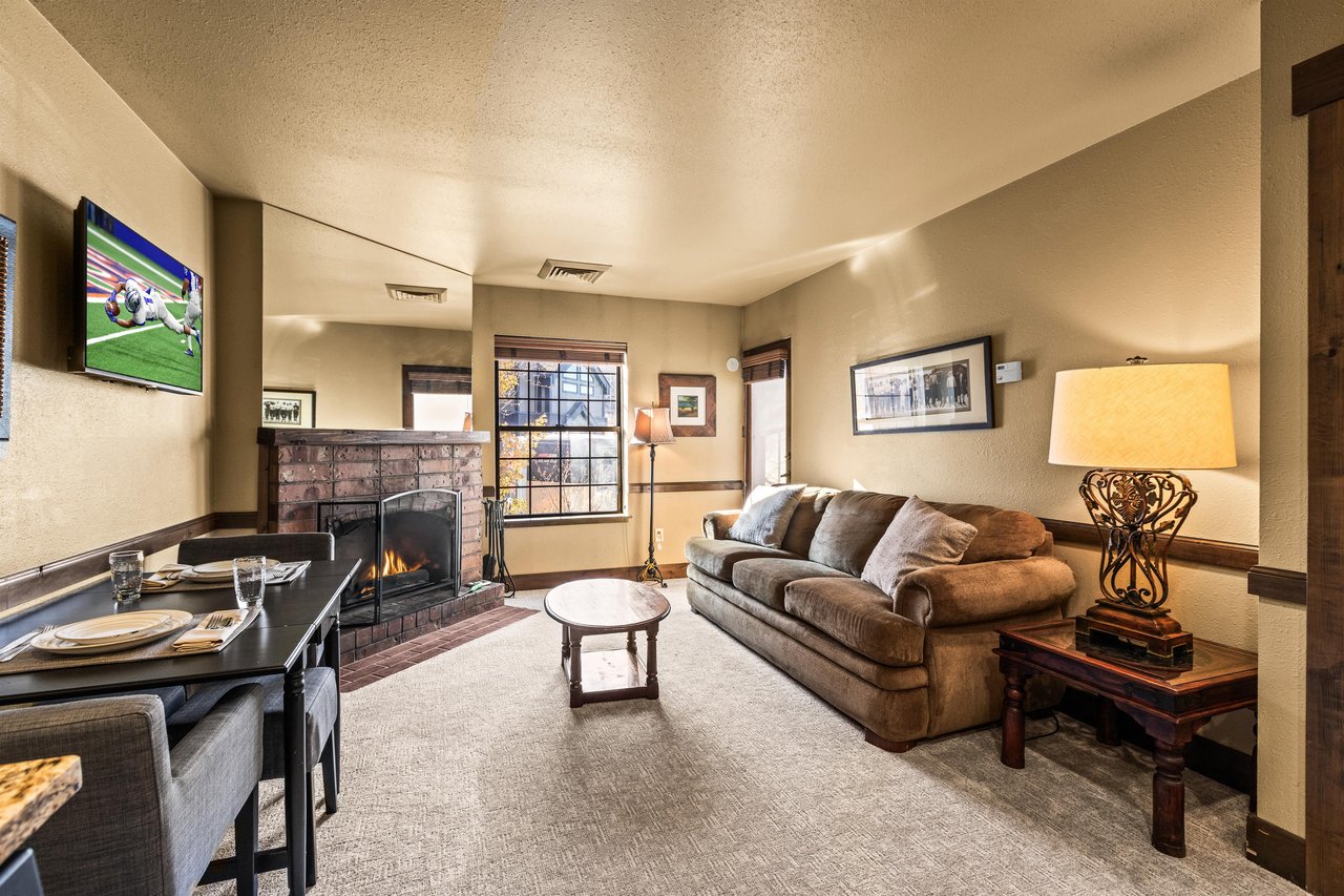Unwind in your cozy living space where a warm fireplace crackles beside plush seating and modern amenities.