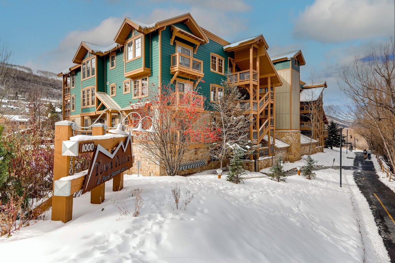 This stunning mountain lodge welcomes you with its charming green facade and warm wood accents, nestled perfectly in fresh powder snow.