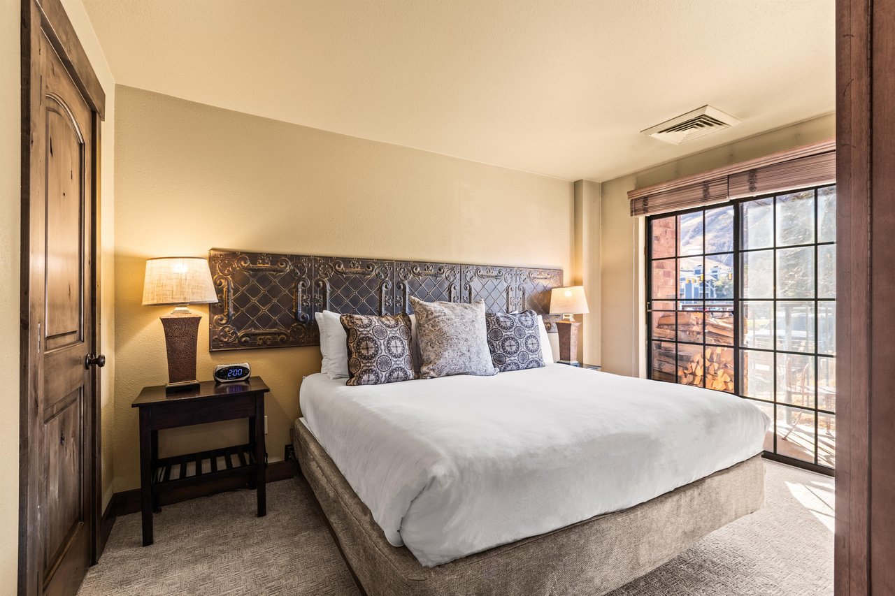 The main suite bedroom with a king size bed and large sliding glass door leading to a private patio.