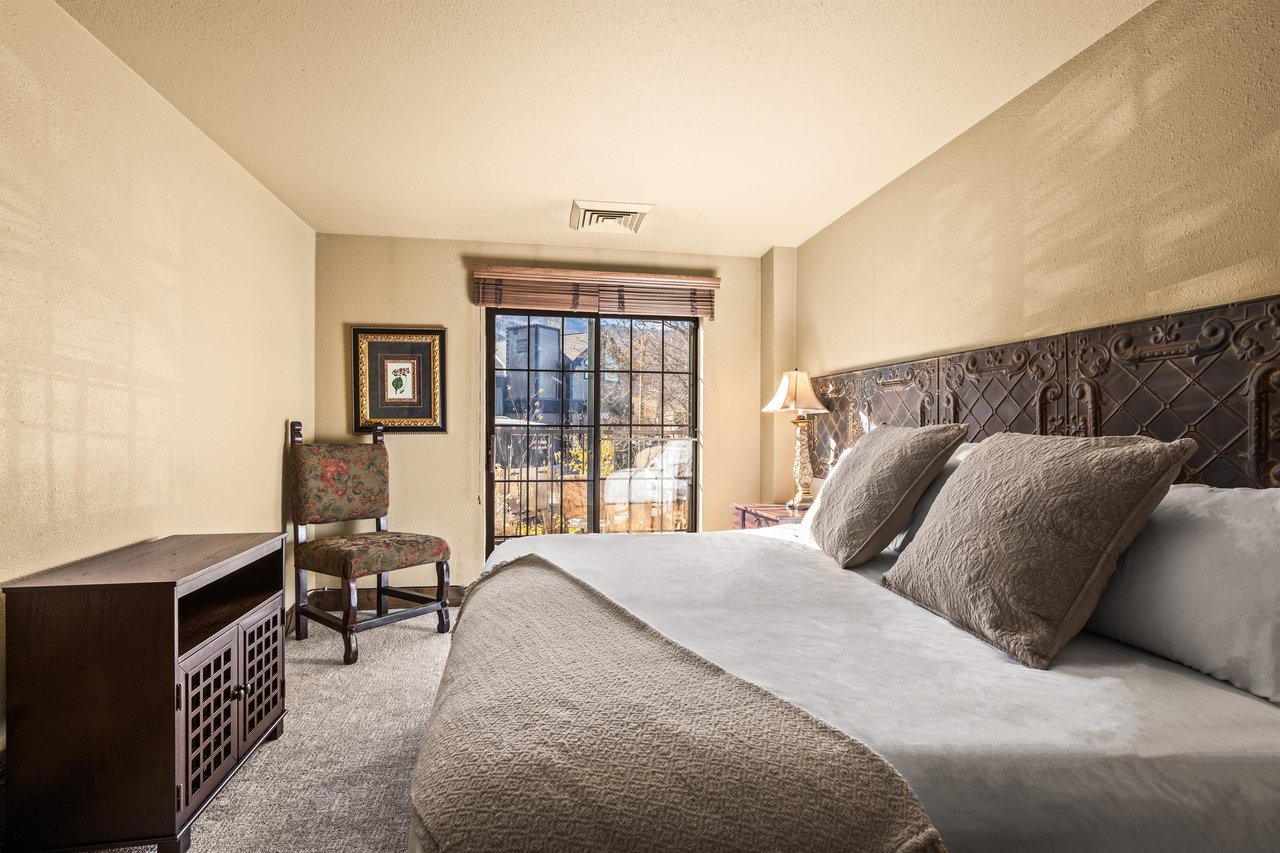 Sink into luxury in your serene bedroom, where an ornate carved headboard and plush linens create the perfect retreat.