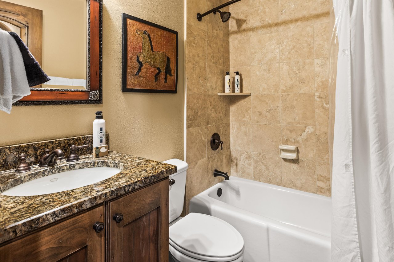 Step into your private sanctuary where warm walls and rich granite countertops create an elegant spalike retreat.
