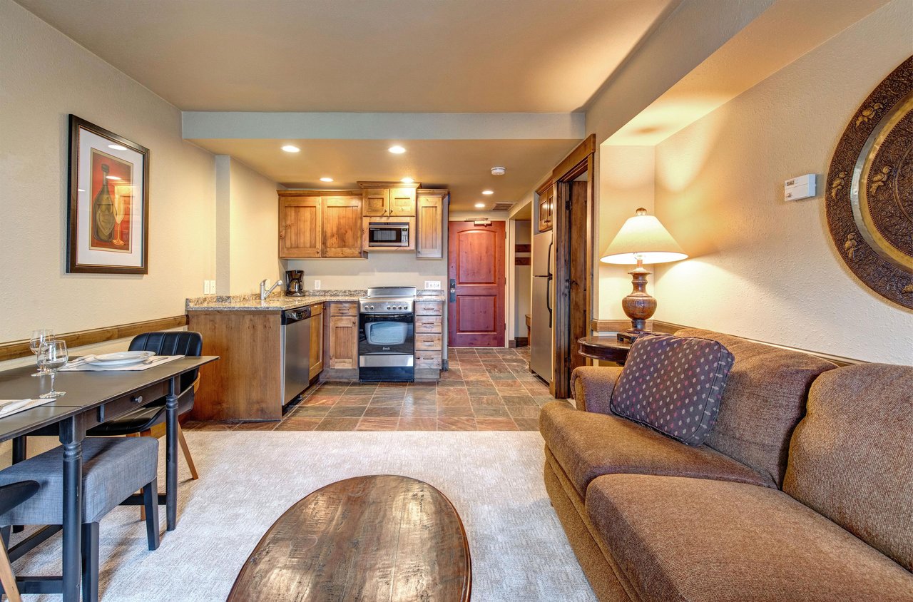 Your cozy openconcept space combines a fully equipped kitchen with warm wood cabinets and a stylish dining area.