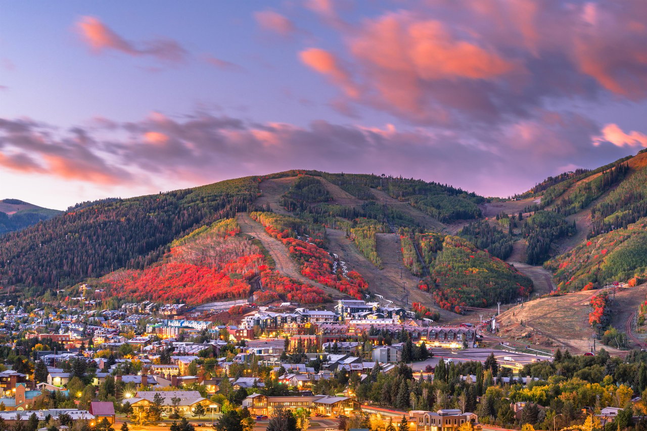 Park City at dusk with the red fall colors lighting up the hillside at Park City Mountain Resort.