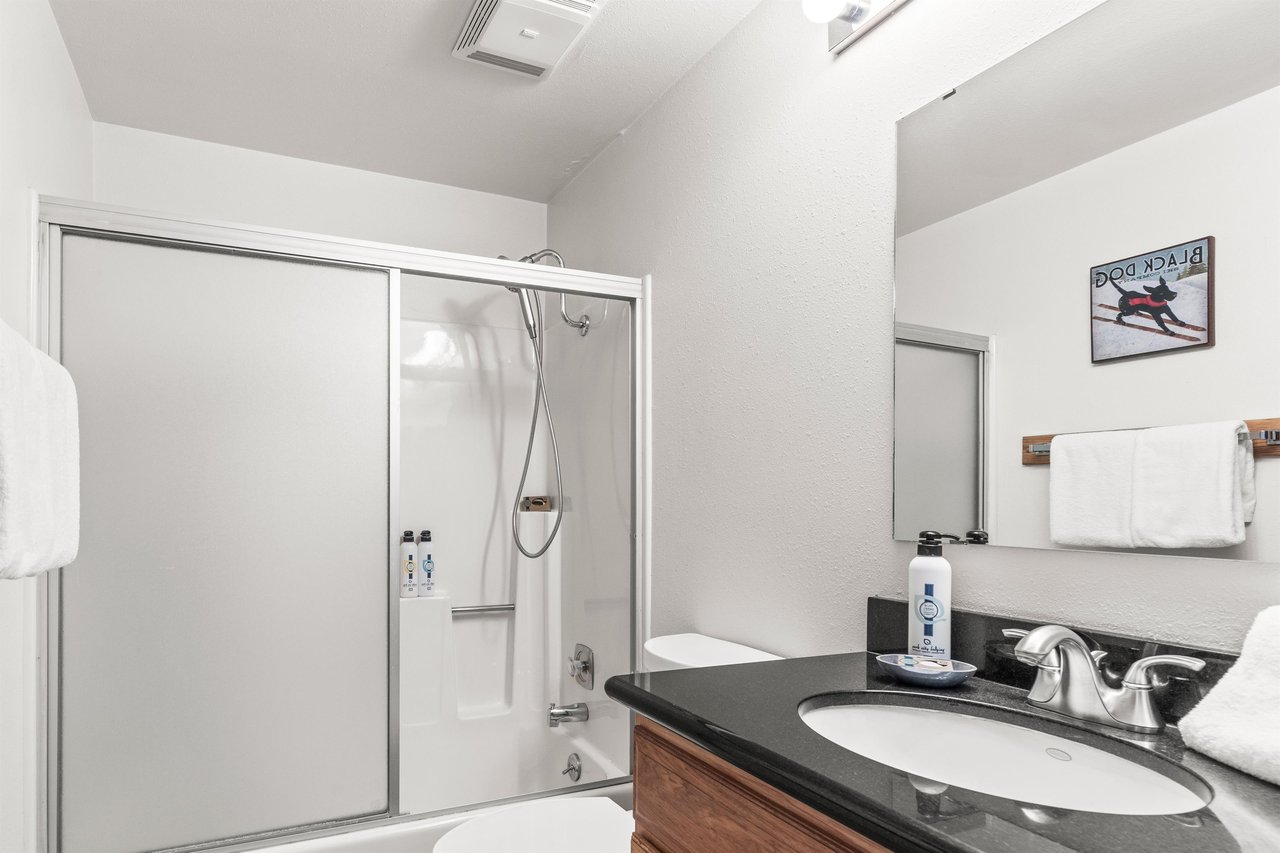 Refresh in your private bathroom featuring a modern showertub combo, granite vanity, and complimentary amenities.