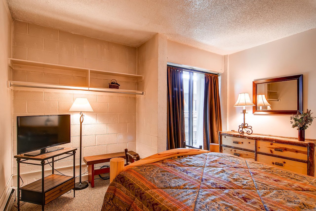 The guest bedroom with a king bed and TV.