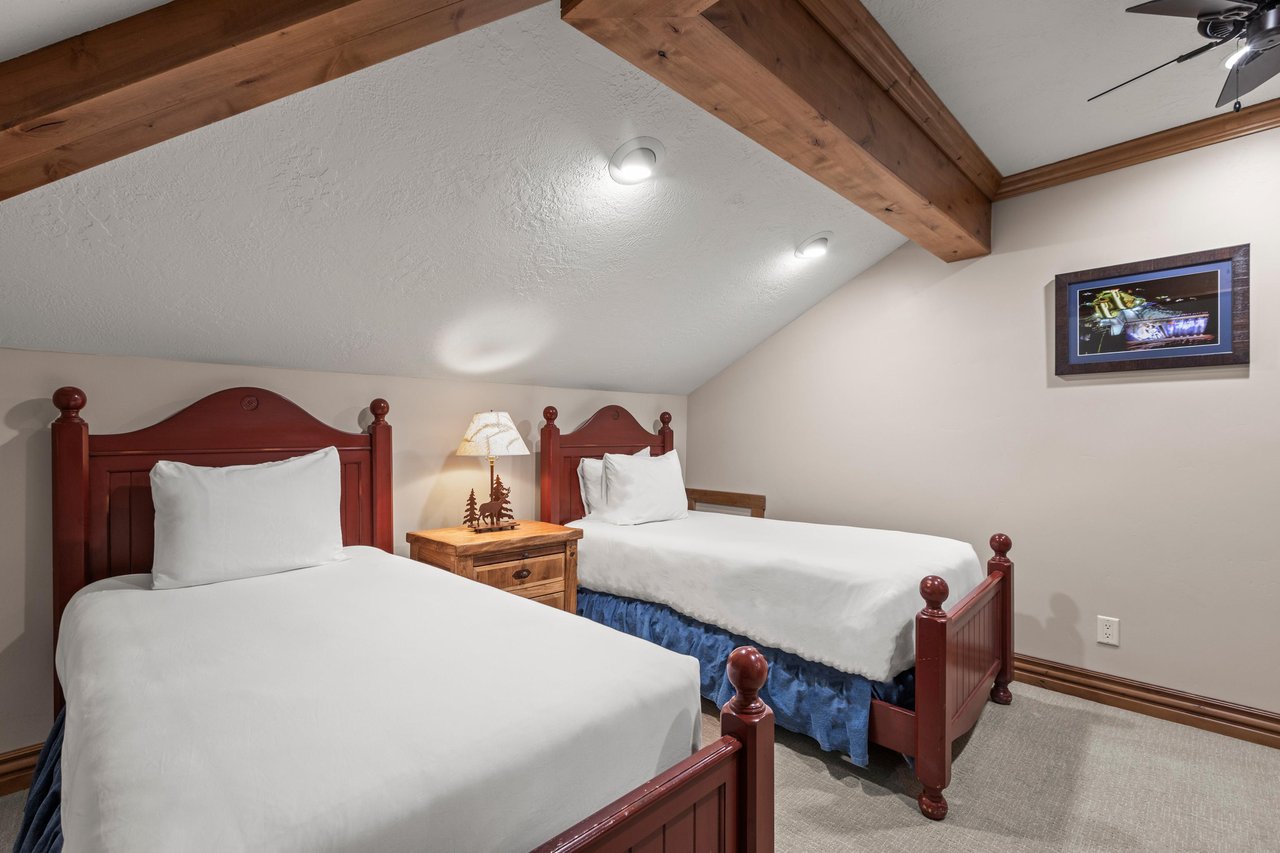 Cozy twin beds await under rustic exposed beams, with your own wallmounted TV for evening entertainment.