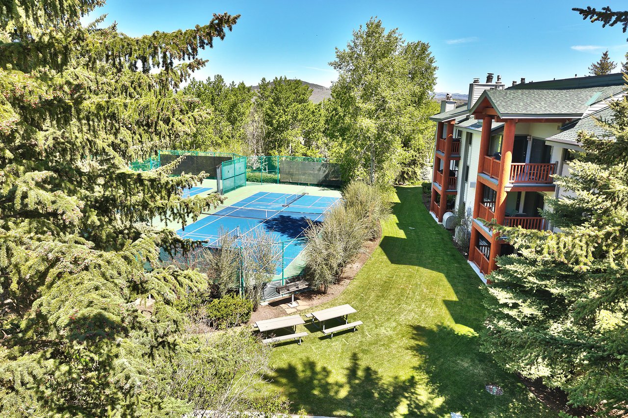 The private patio shows views of the tennis courts in the summer