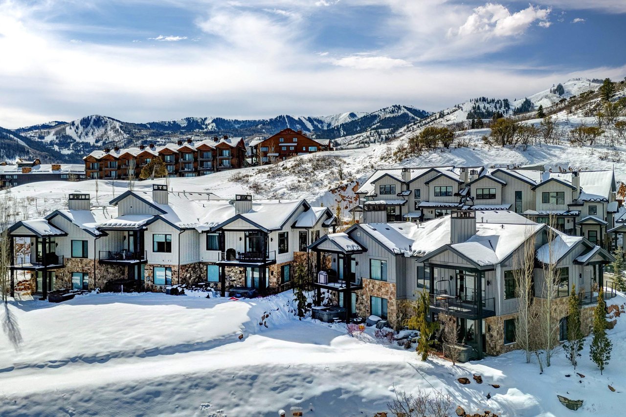 Mountain resort community nestled in pristine snowcovered slopes with dramatic alpine peaks creating a stunning winter backdrop.