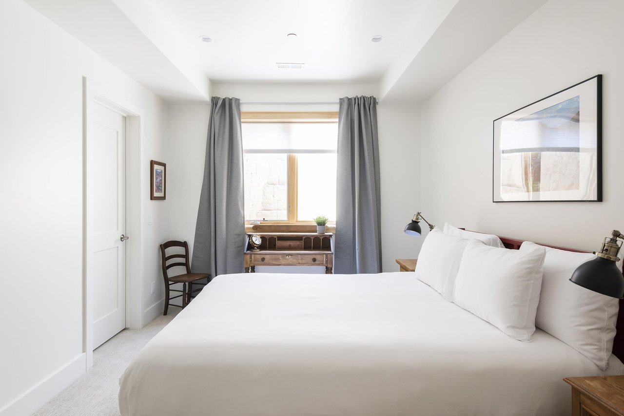 3rd guest bedroom with queen bed and window facing work or study desk