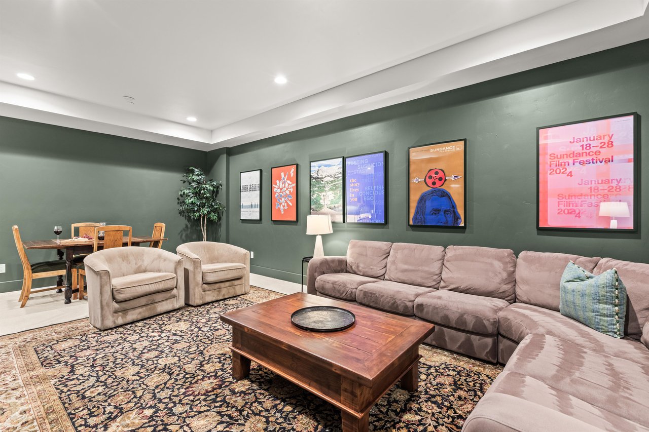 Sink into plush sectional seating surrounded by vibrant film festival posters and warm lighting, perfect for movie nights.