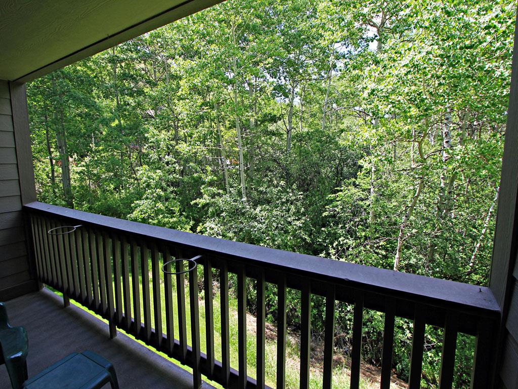 Enjoy the private patio with forest views in the summer at the Snow Flower 149 vacation rental.