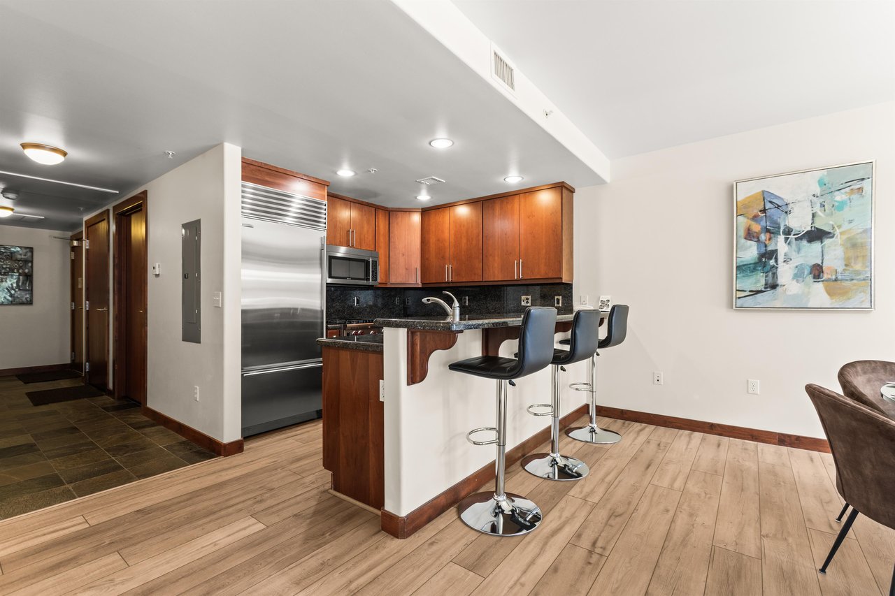 The modern kitchen features stainless steel appliances and a convenient breakfast bar with seating for 3 guests.