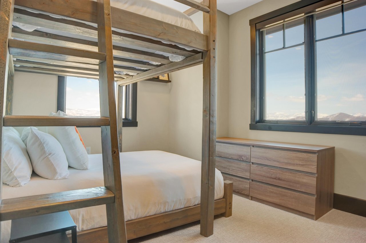 The bunk room with large windows and well appointed wood furniture.