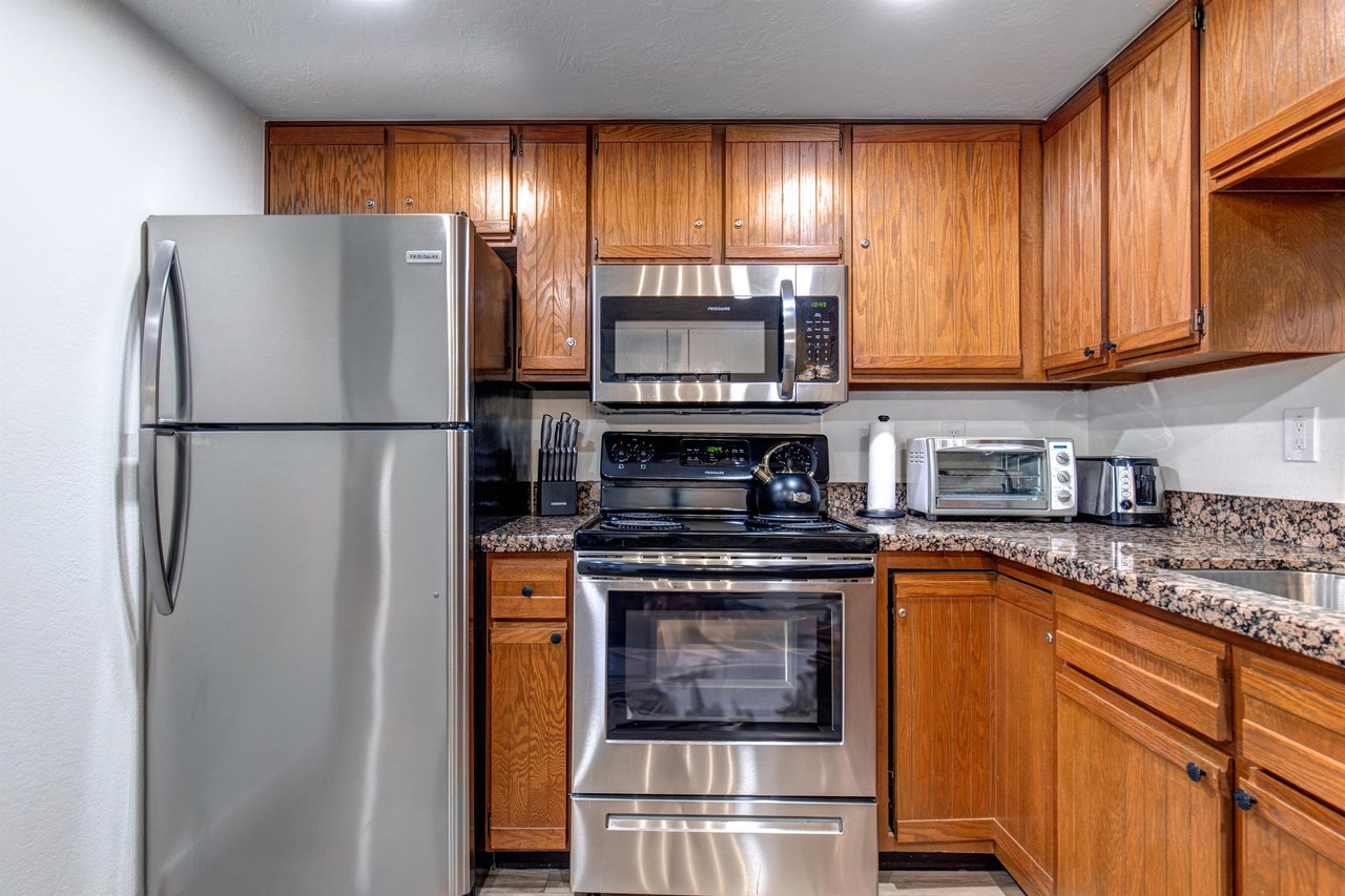 Park Station 133s kitchen has sparkling stainless steel appliances and a toaster over on top of the counter.