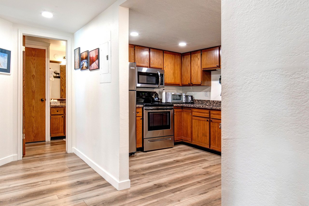 The kitchen sits next to a hallway leading to the main suite.