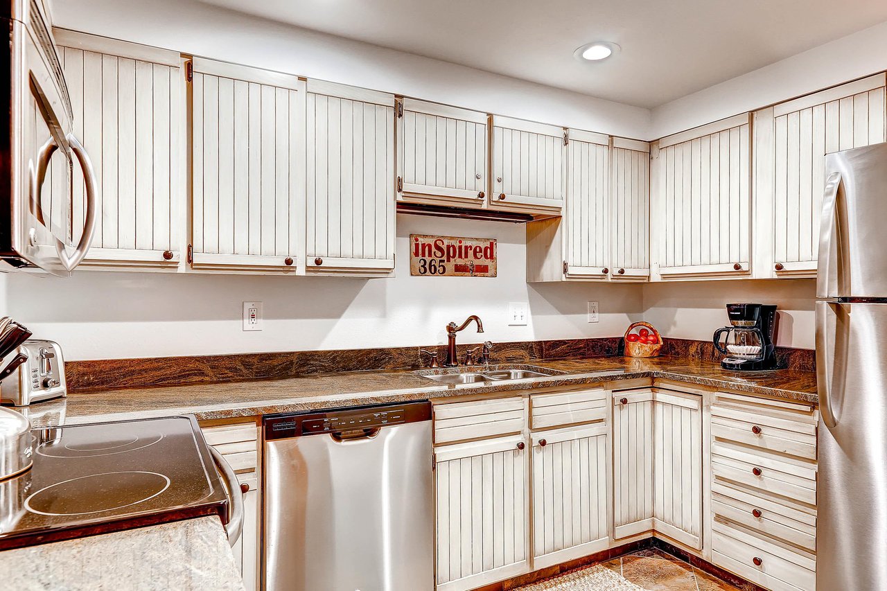 Park Station 134s kitchen with white cabinets, recessed lighting, and stainless steal appliances.